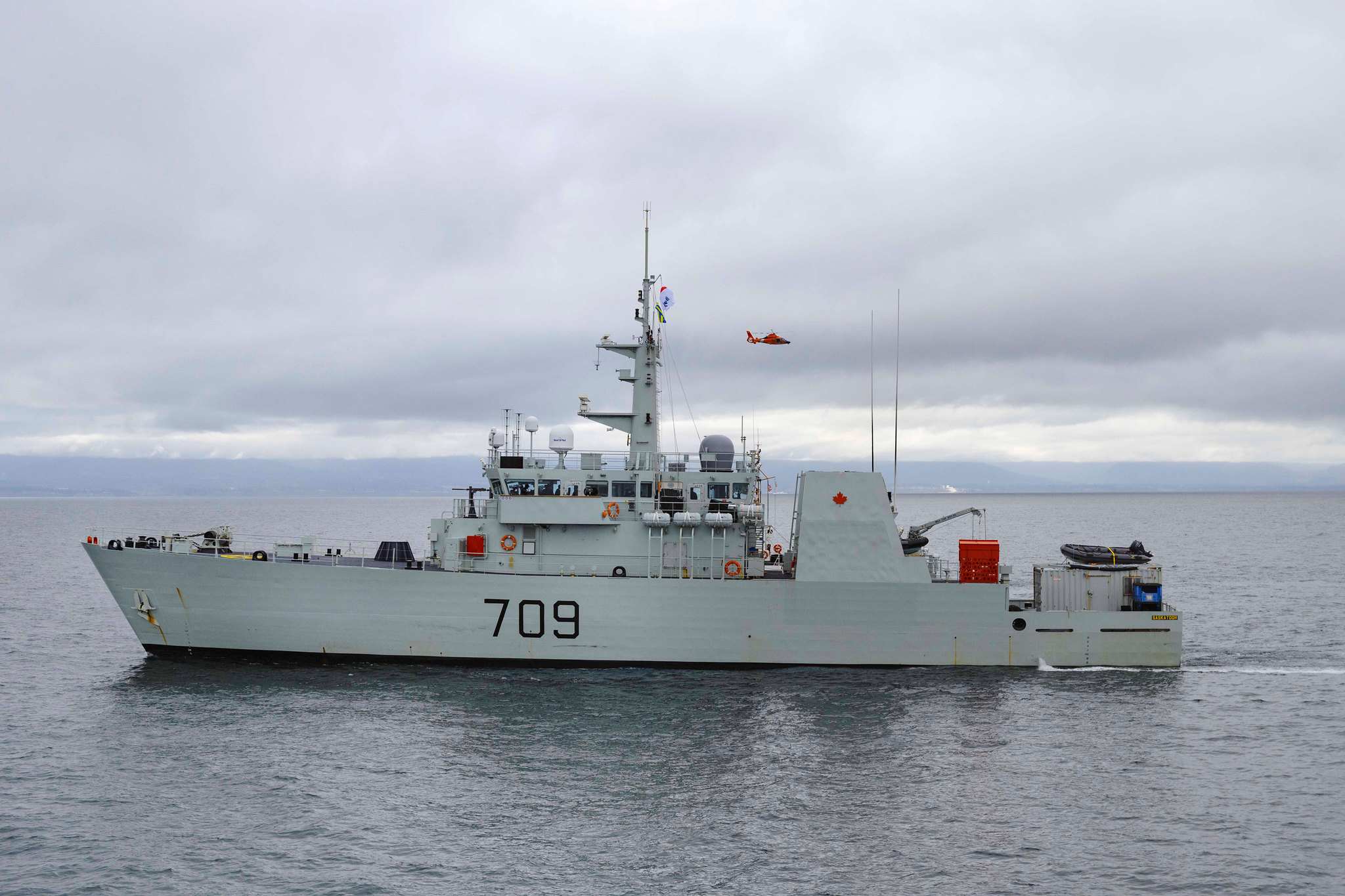 A USCG Helicopter flies over HMCS SASKATOON, Operation CARIBBE, February 17, 2022. Photo: MARPAC Imaging Services