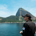 Lieutenant (Navy) Logan Rook, a Logistics Officer onboard HMCS MARGARET BROOKE, observes Sugarloaf Mountain off the starboard bridge wing as the ship departs Rio de Janeiro during Operation PROJECTION 25-01 on 4 February 2025. Photo by: Corporal Connor Bennett, Canadian Armed Forces Photo.