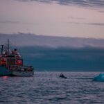 Members of HMCS MARGARET BROOKE ride in a Multi-Role Rescue Boat (MRRB) toward the ship as part of a personnel transfer from Rothera Research Station, Adelaide Island, Antarctica, during Operation PROJECTION 25-01 on 15 March 2025. Photo by: Corporal Connor Bennett, Canadian Armed Forces Photo.