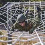 RAVEN Program recruits climb across cargo netting on the Confidence Course at Camp Albert Head, Victoria, British Columbia on 28 July 2021. Photo: S1 Kendric C.W. Grasby, Canadian Armed Forces Photo