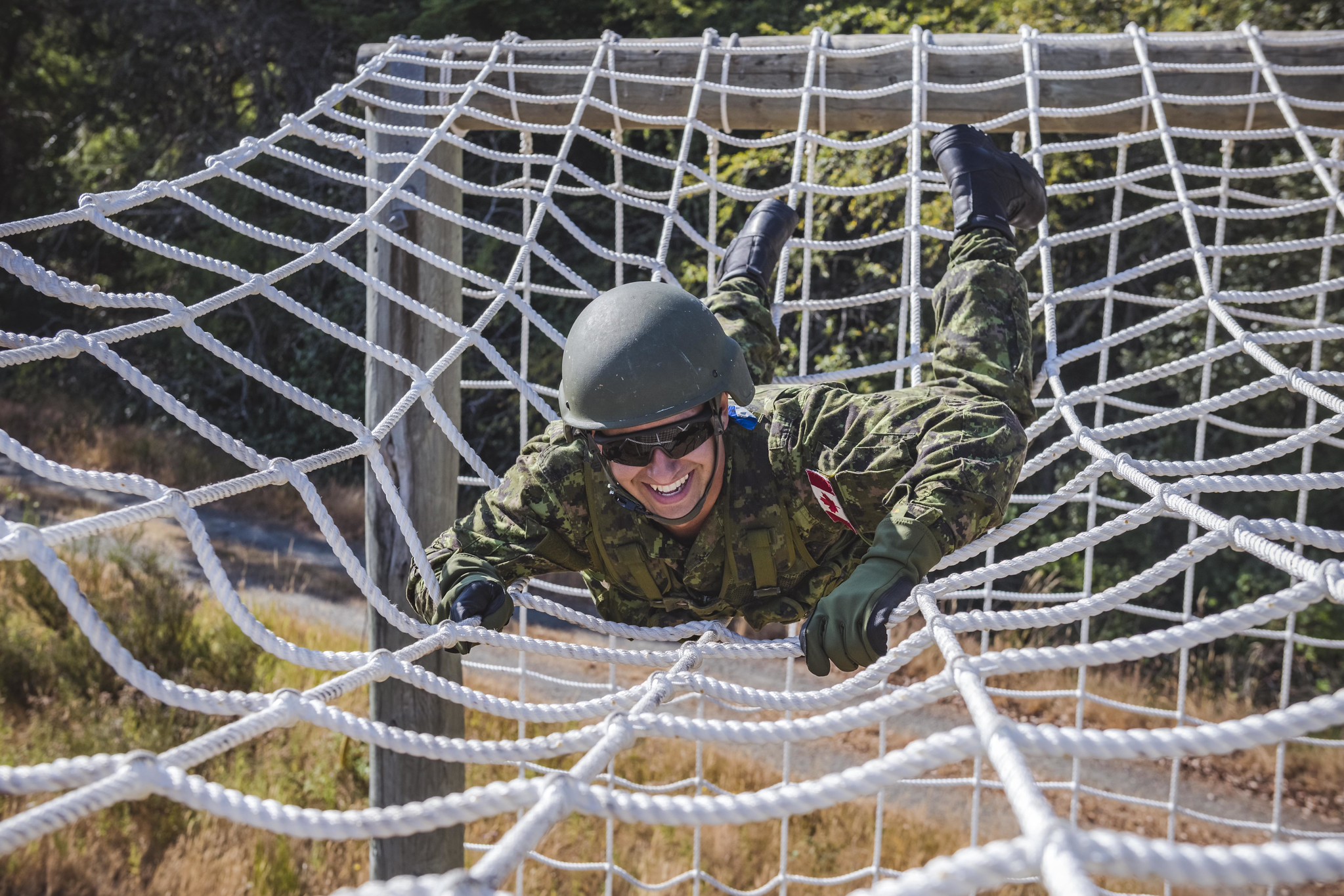 RAVEN Program recruits climb across cargo netting on the Confidence Course at Camp Albert Head, Victoria, British Columbia on 28 July 2021. Photo: S1 Kendric C.W. Grasby, Canadian Armed Forces Photo
