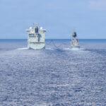 Canadian supply ship MV Asterix extends its fuel boom to Royal Australian Navy (RAN) Anzac-class frigate HMAS Toowoomba (FFH 156) in front of Royal Canadian Navy Halifax-class frigate HMCS Charlottetown (FFH 339) and U.S. Navy Whidbey Island-class dock landing ship USS Ashland (LSD 48) during a multilateral exercise with RAN and Royal Canadian Armed Forces in the South China Sea, April 14, 2026. (U.S. Navy photo by Mass Communication Specialist 1st Class John B. Hetherington)