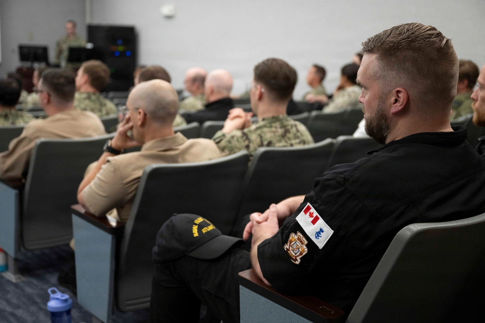 U.S. Navy, Canadian Royal Navy, and British Royal Navy Sailors receive a brief during the Fall 2026 Theater Undersea Warfare Symposium, held at Naval Support Activity - Hampton Roads, Aug. 25, 2026.
